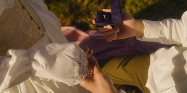 Vintage-inspired outdoor proposal with engagement ring and romantic atmosphere.
